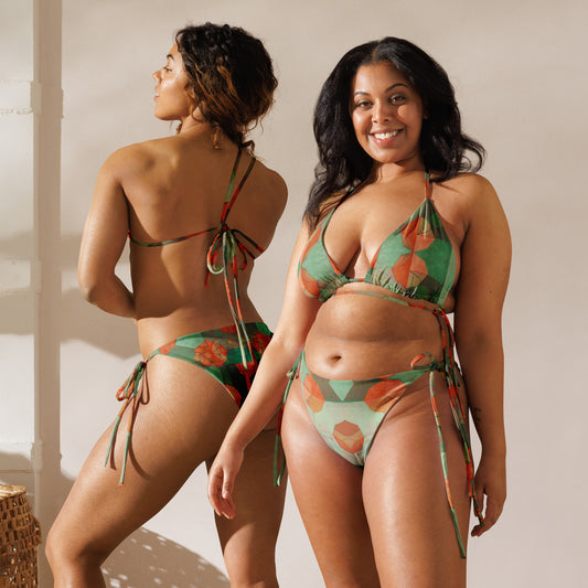 Two models wearing Recycled String Bikinis with multicolored geometric patterns. One model is facing forward, and the other is showing the back view, highlighting the adjustable ties of the bikini top.