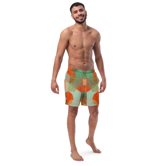 A man standing and facing forward, wearing multicolored swim trunks with a geometric pattern.