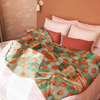 Bed with a geometric patterned quilt and red pillows against a beige wall.