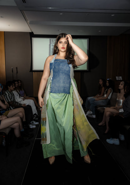 Model walking on a runway wearing a Tender Emergence dress with a long train.