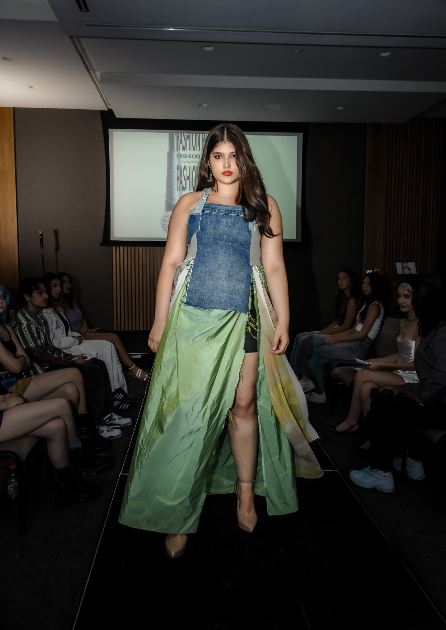 Model walking on a runway wearing upcycled denim and silk dress, skirt moving in the wind, from Sarah Tremain’s 'You Have Everything You Need' collection.