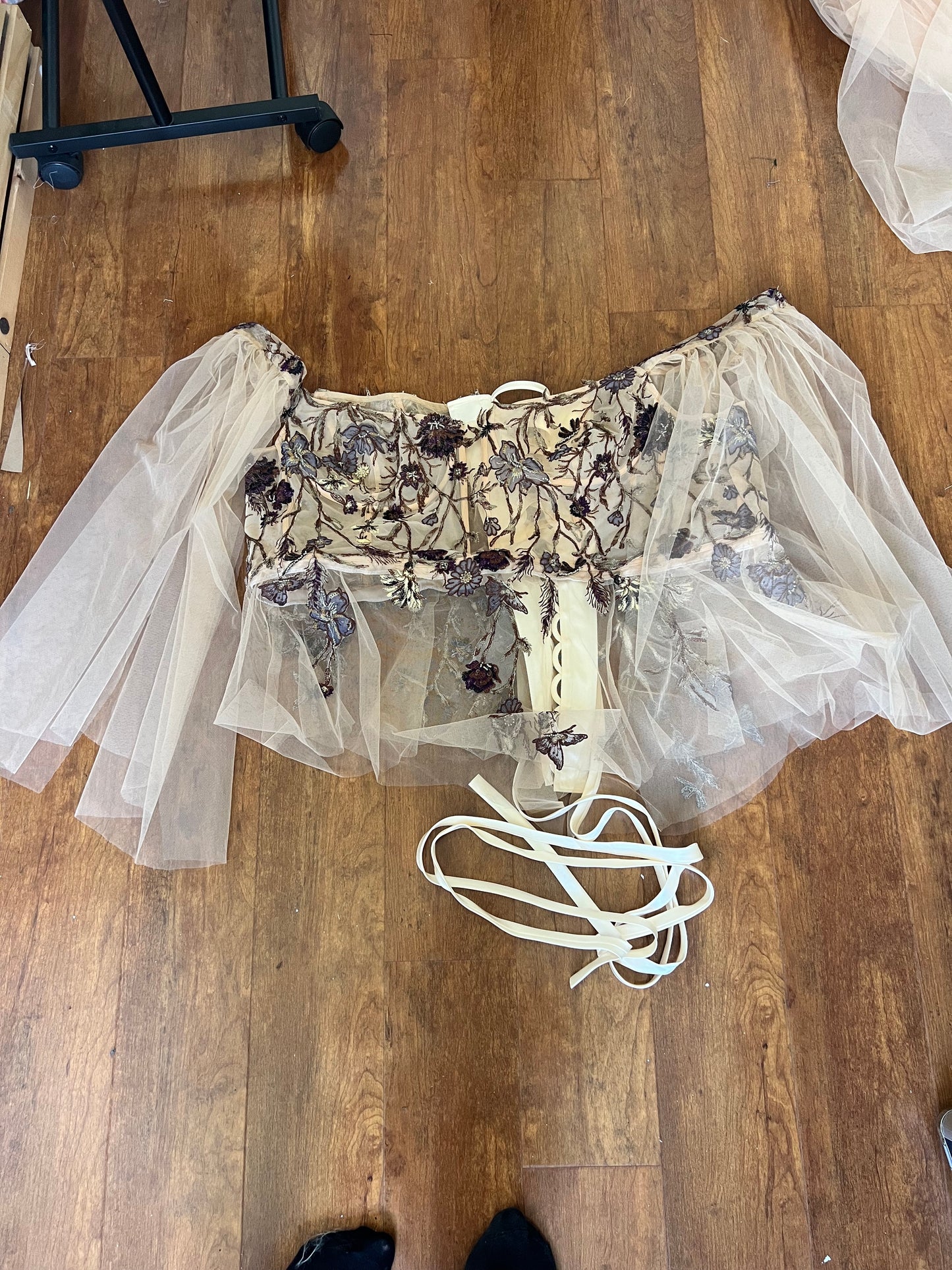 Upcycled Wedding Dress turned corset top laying on wood floor